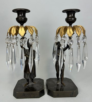 Lot 668 - A PAIR OF BRONZE CANDLESTICKS DEPICTING MALE...