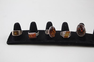 Lot 200 - A COLLECTION OF SILVER AND AMBER RINGS...