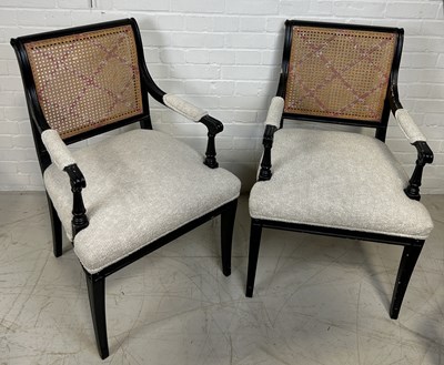 Lot 1044 - A PAIR OF EBONISED BLACK ARMCHAIRS WITH CANED BACKS