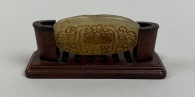 Lot 220 - A CARVED JADE DISC IN THE ARCHAIC STYLE, WITH WOODEN STAND