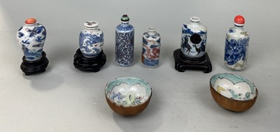 Lot 602 - A COLLECTION OF SIX CHINESE QING DYNASTY SNUFF BOTTLES, THREE WITH STOPPERS AND ROSEWOOD STANDS ALONG WITH TWO SMALL WINE CUPS