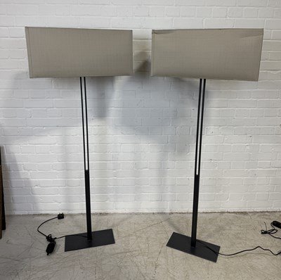 Lot 775 - CHRISTIAN LIAGRE: A PAIR OF METAL FLOOR LAMPS WITH GREY SHADES.