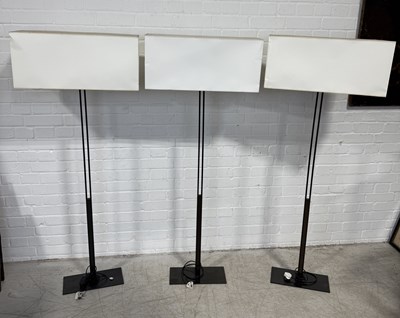 Lot 748 - CHRISTIAN LIAGRE: THREE BRONZE FLOOR LAMPS WITH WHITE SHADES