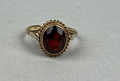 Lot 330B - A 9CT GOLD RING SET WITH AN OVAL RED STONE