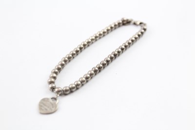 Lot 244 - A TIFFANY AND CO STERLING SILVER BALL LINK BRACELET WITH A HEART TAG