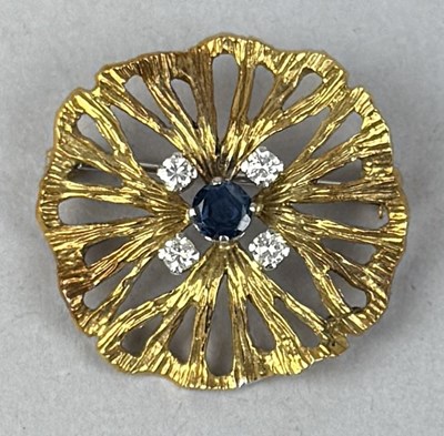 Lot 389 - AN 18CT GOLD FLORAL BROOCH SET WITH FOUR DIAMOND, AND A CENTRAL SAPPHIRE