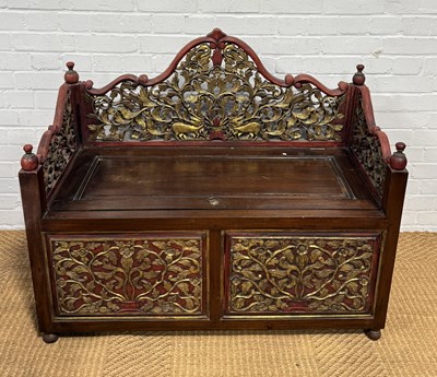 Lot 102 - AN INDONESIAN CARVED AND PART GILDED WOODEN CHEST/SETTEE WITH HINGED LID AND STORAGE COMPARTMENT, JAVA, INDONESIA CIRCA 1940