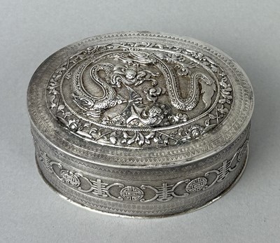 Lot 31 - A CHINESE SILVER OVAL LIDDED BOX FINELY CHASED WITH DRAGON AN DBANDS OF LONG LIFE SYMBOLS, CHINA, LATE 19TH CENTURY