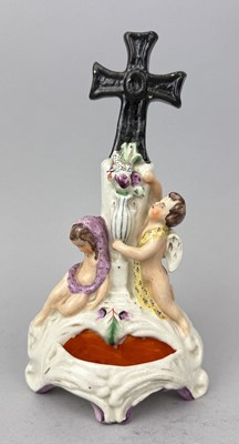 Lot 522 - STAFFORDSHIRE, A CROSS ABOVE A CHERUB ARRANGING FLOWERS IN A VASE, CIRCA 1860'S