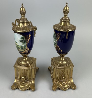 Lot 1075E - A PAIR OF FRENCH CERAMIC AND GILT METAL URNS PAINTED WITH LANDSCAPE SCENES