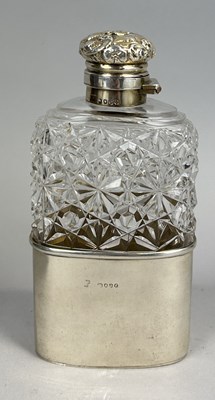 Lot 21 - A VICTORIAN SILVER MOUNTED AND CRYSTAL HIP FLASK WITH FOLIATE DESIGN EMBOSSED TOP