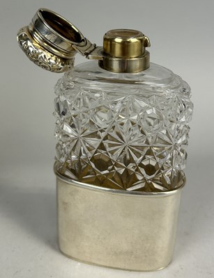Lot 21 - A VICTORIAN SILVER MOUNTED AND CRYSTAL HIP FLASK WITH FOLIATE DESIGN EMBOSSED TOP