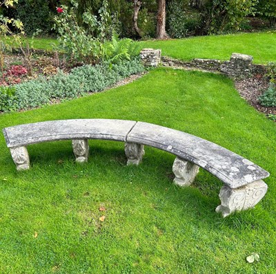 Lot 68 - A reconstituted stone curved garden bench on...