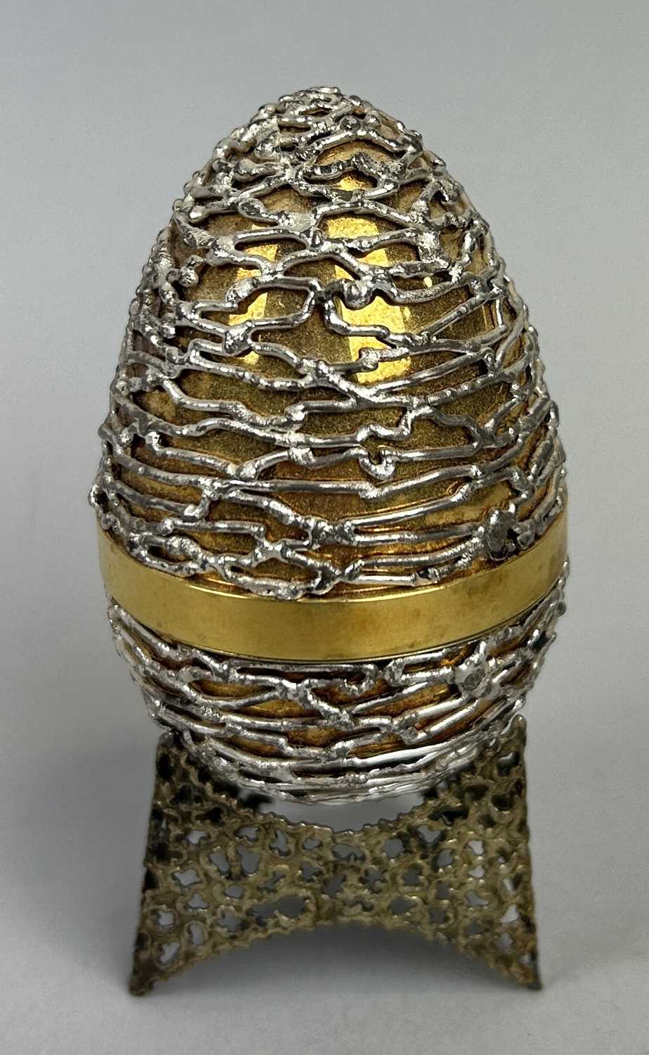 Lot 8 - A STUART DEVLIN SILVER AND GILT SURPRISE EGG AND STAND, OPENING TO REVEAL ENAMEL FLOWERS