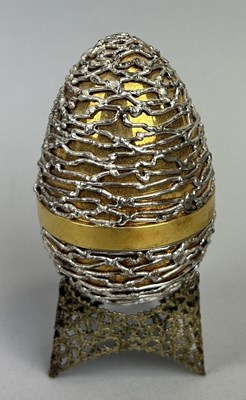 Lot 8 - A STUART DEVLIN SILVER AND GILT SURPRISE EGG AND STAND, OPENING TO REVEAL ENAMEL FLOWERS