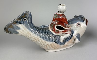 Lot 319 - A JAPANESE ARITA STYLE BOY RIDING A CARP ALONG WITH A BLUE GLAZED CERAMIC BOWL, CHINESE BRUSH POT AND GLAZED DOG RELIEF