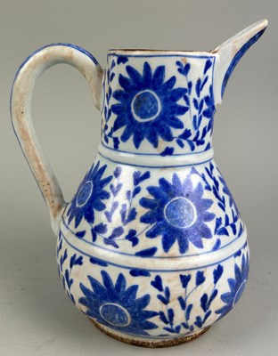 Lot 132 - AN ISLAMIC JUG BLUE AND WHITE PAINTED WITH...