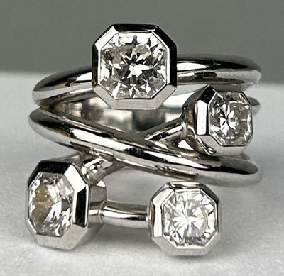 Lot 1 - A PLATINUM RING SET WITH FOUR CORNER SQUARE...