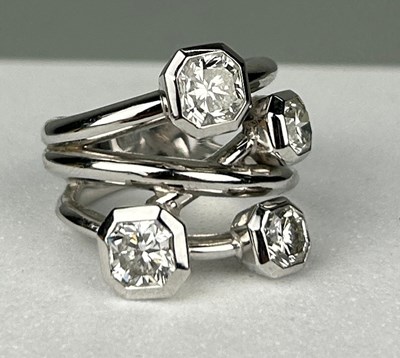 Lot 1 - A PLATINUM RING SET WITH FOUR CORNER SQUARE...