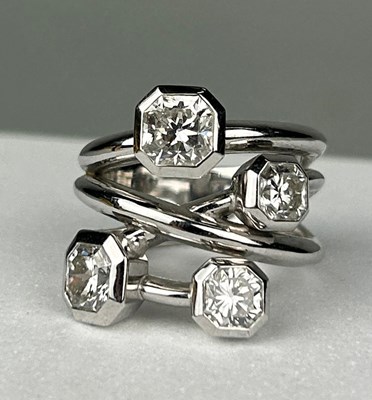 Lot 1 - A PLATINUM RING SET WITH FOUR CORNER SQUARE...