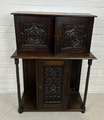 Lot 654 - AN ELIZABETHAN STYLE OAK CUPBOARD WITH CARVED GOTHIC FRONT PANELS AND BARLEY TWIST SUPPORTS