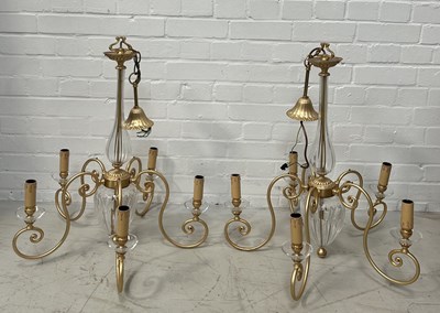 Lot 634 - A PAIR OF 'CHELSOM' GLASS CHANDELIERS EACH WITH FIVE SCROLLING BRASS ARMS